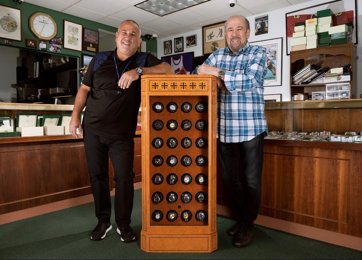 Howard Frum and a colleague in the watch store beside a display of timepieces